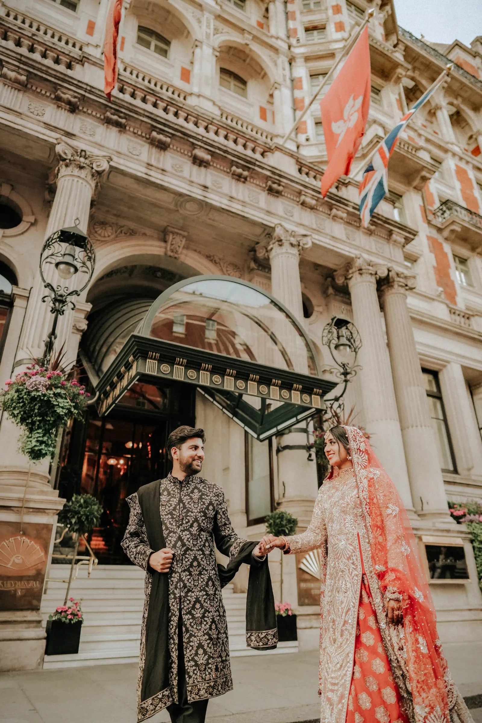 Groom leading his bride by the hand outside the Mandarin Oriental, Hyde Park