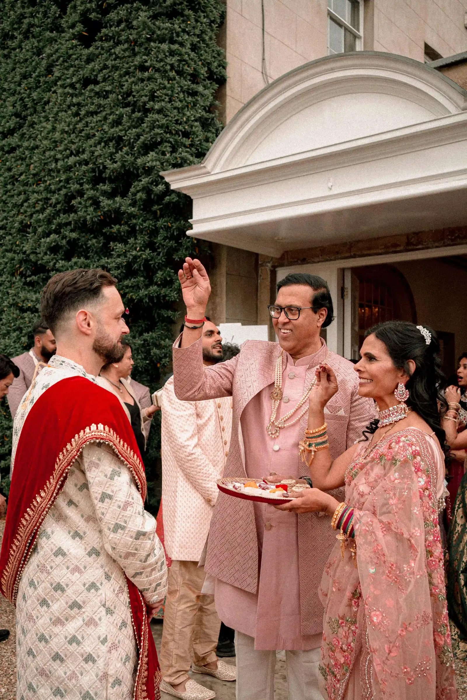 The greeting party welcoming the groom with a tray at the entrance