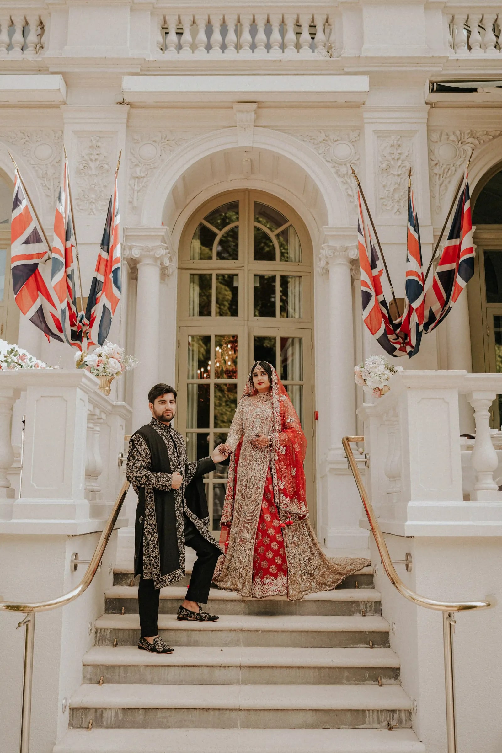 Bride and groom on the hotel steps, Union flags on either side of the doorway