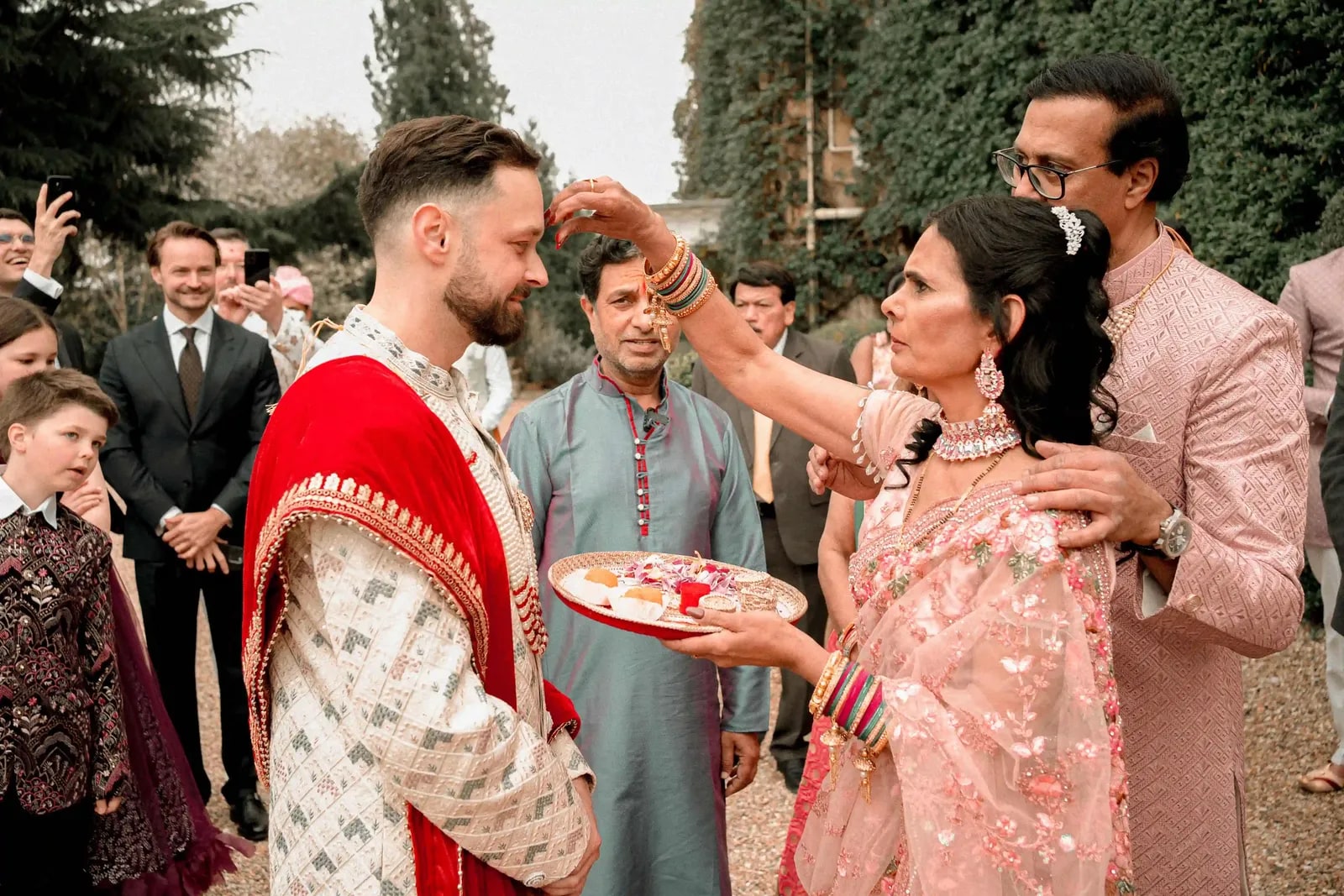 The groom receiving a tilak from the bride's mother at the door