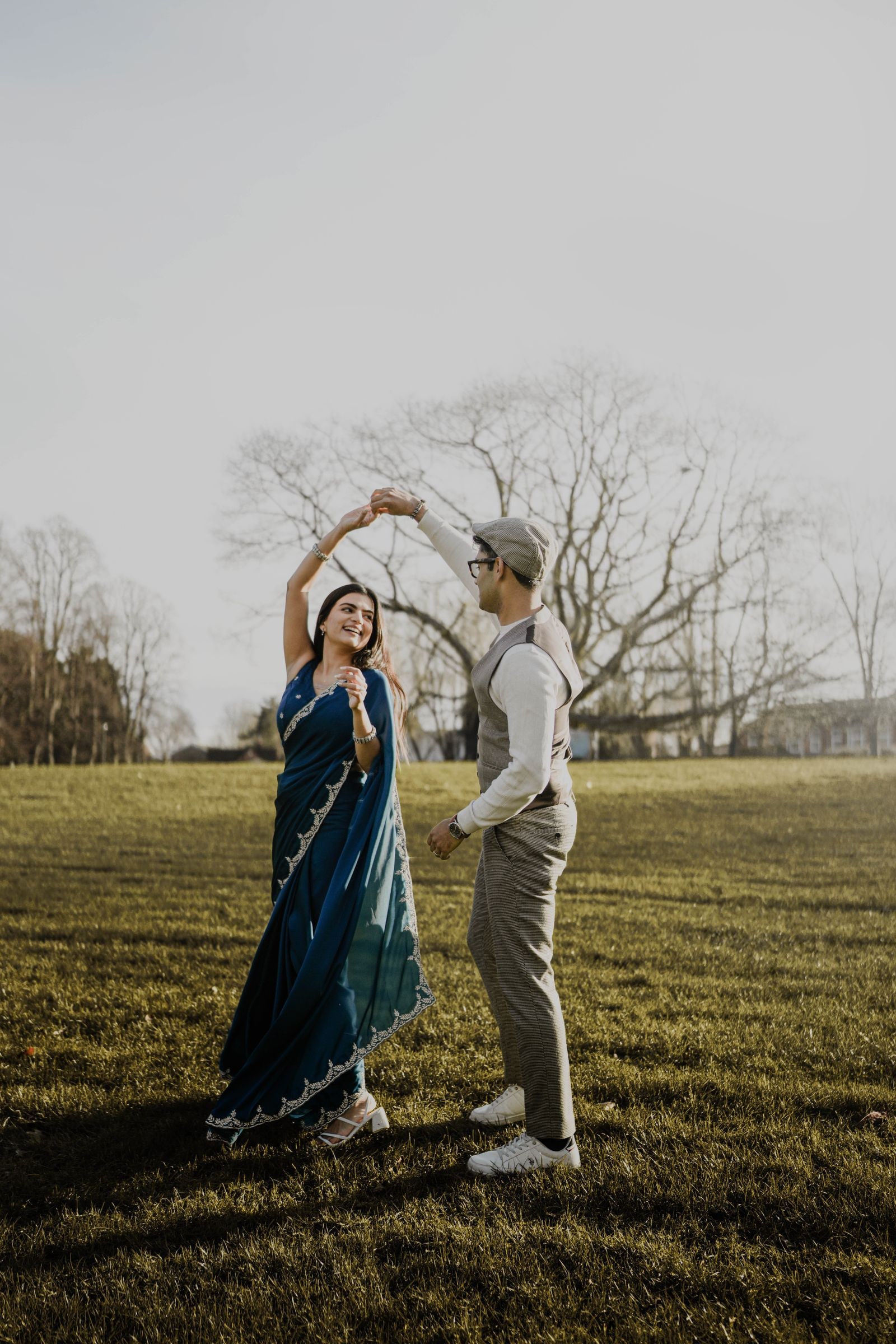 Couple dancing in a field, he turning her under his arm