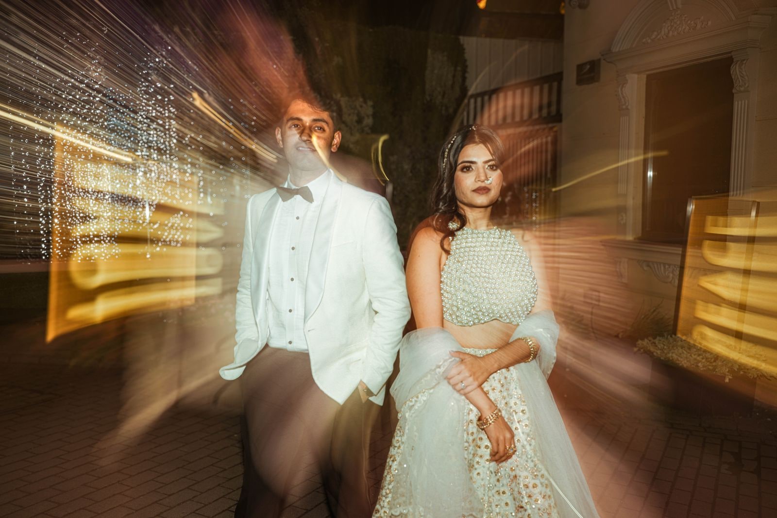 Couple standing still while the lights around them streak into long trails