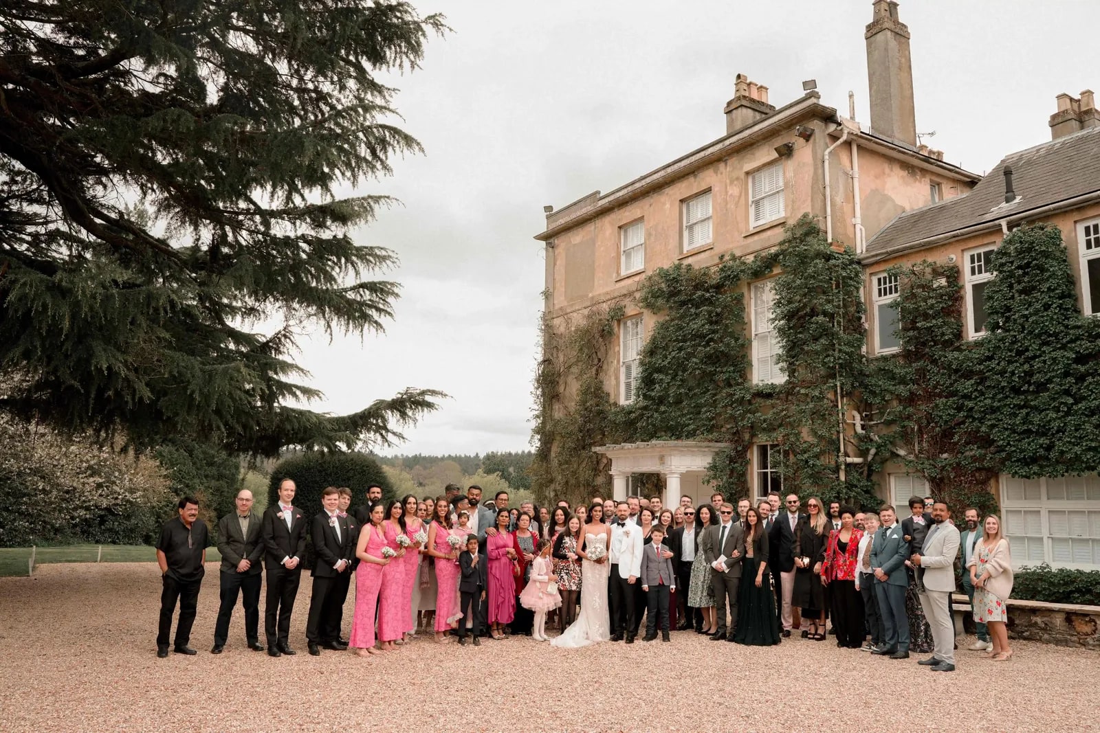 The full group of guests assembled on the drive in front of the house
