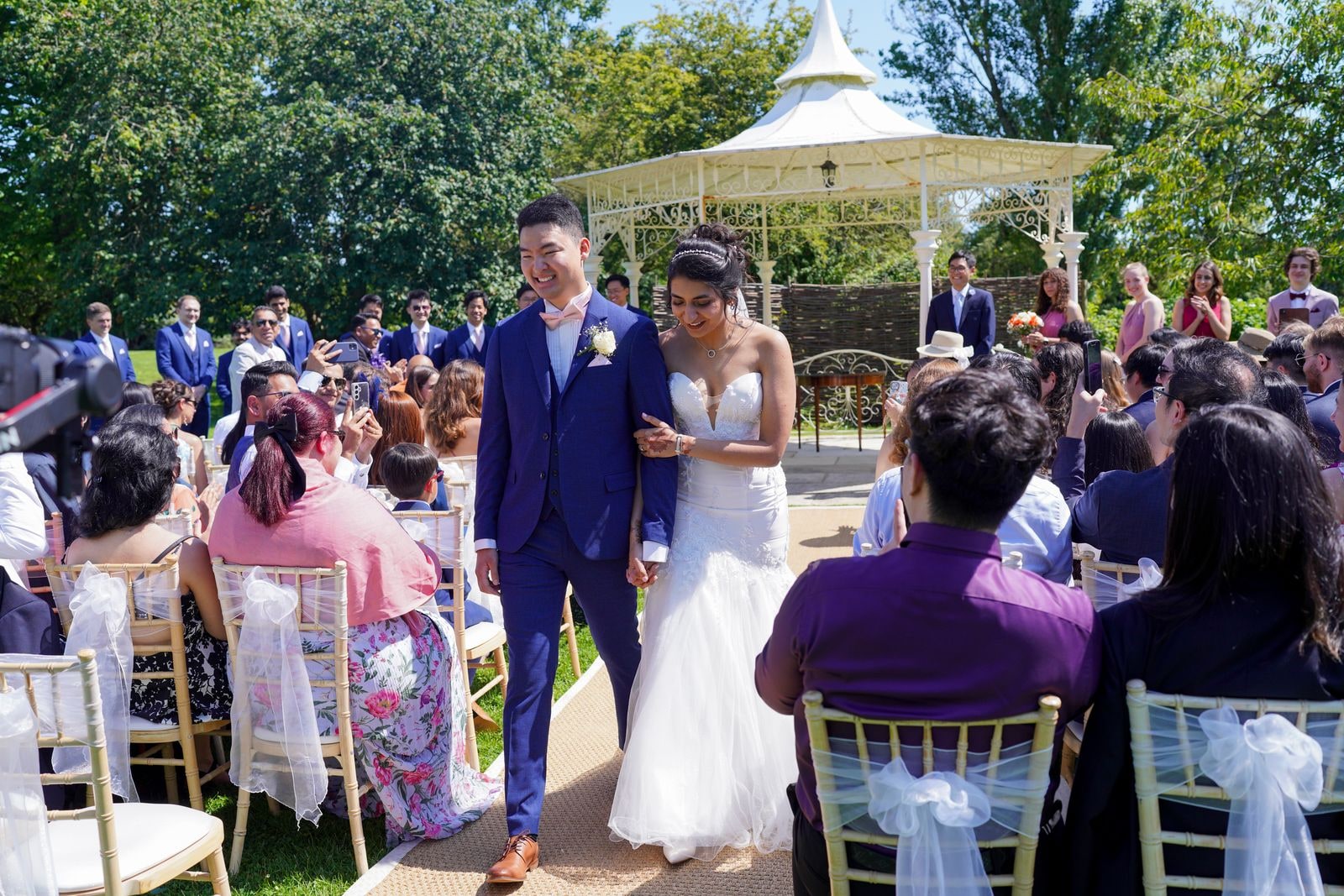 The couple coming down the aisle as guests applaud from both sides