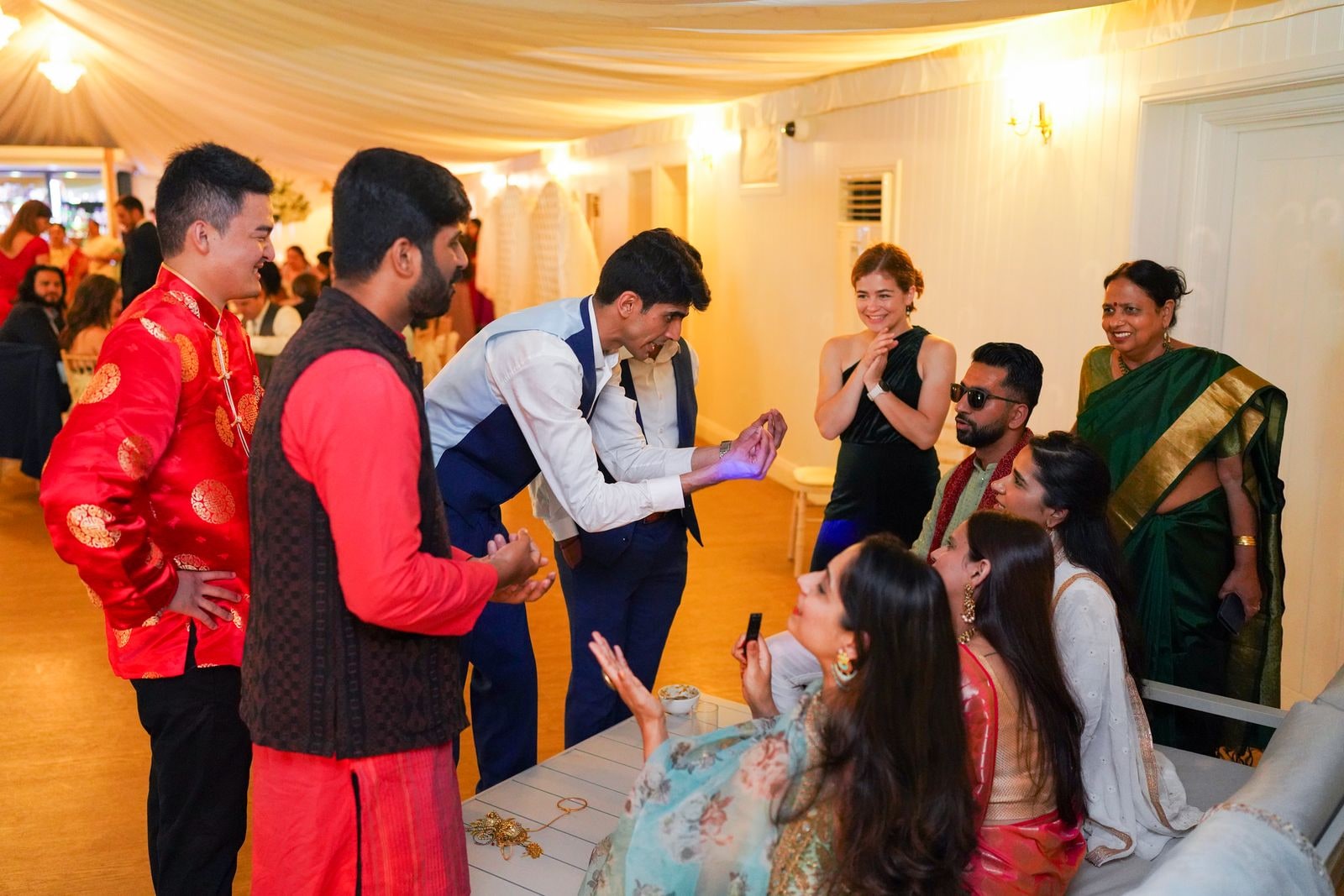 Guests dancing together in the marquee, the groom in his red jacket among them