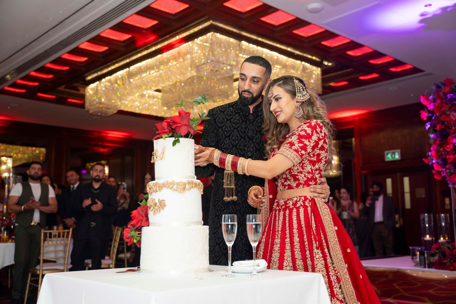 Bride and groom cutting the tiered cake at the reception