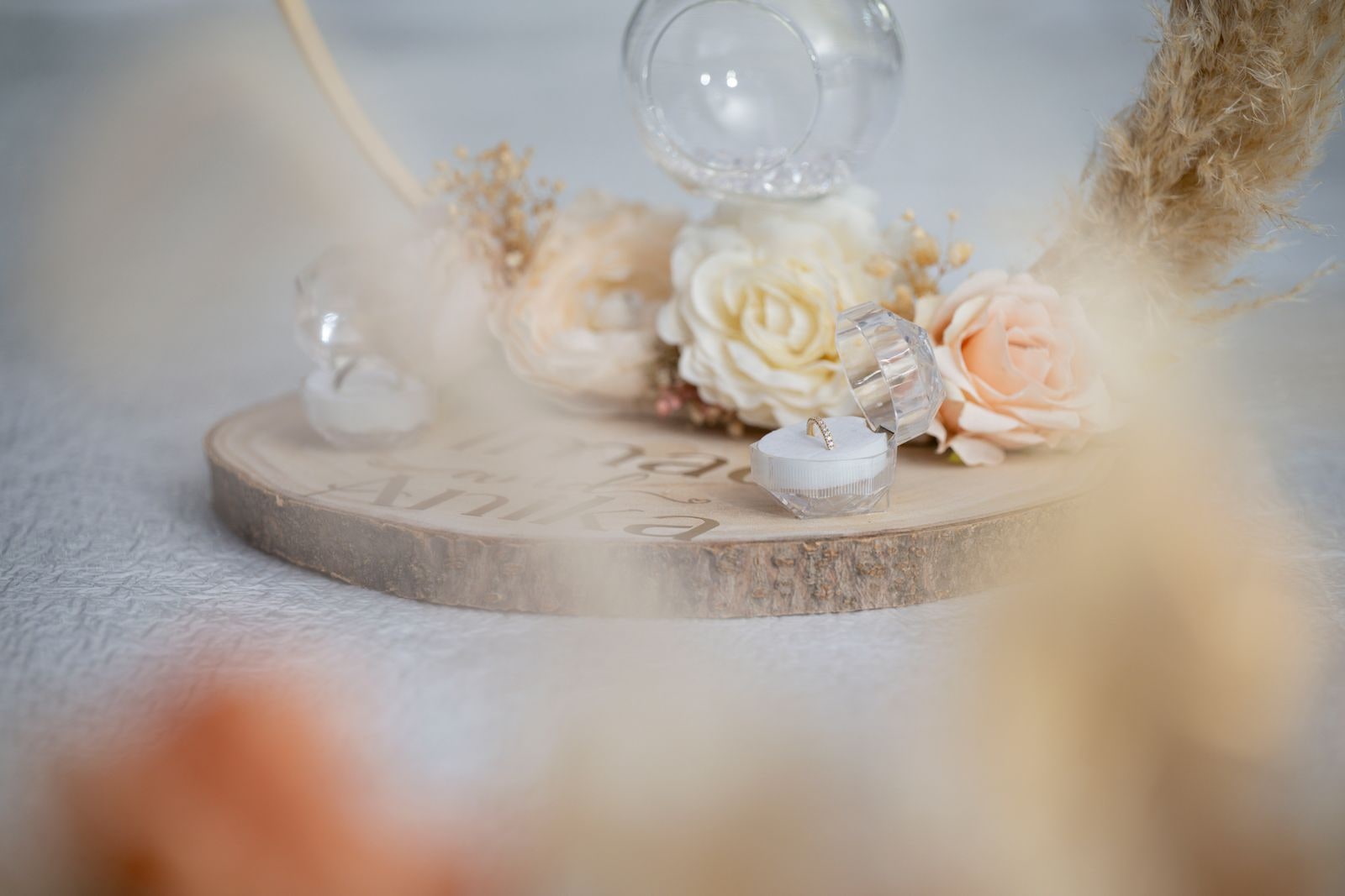The rings on a wooden dish with cream roses and dried grasses
