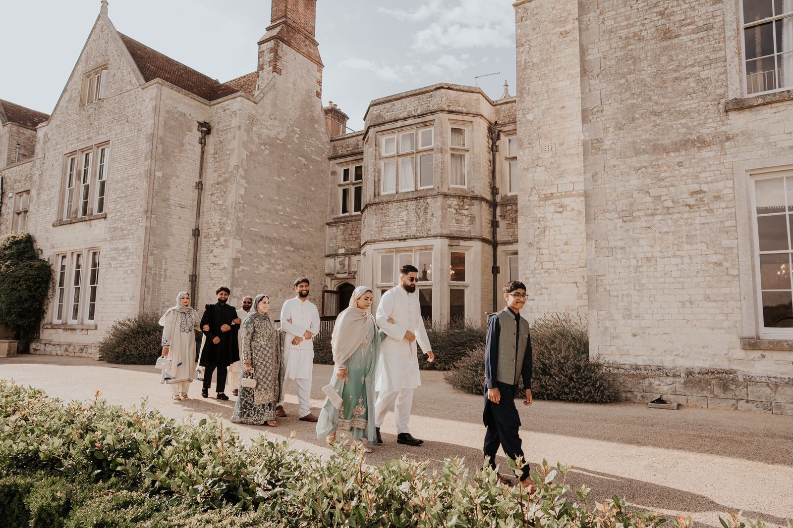 Guests walking the path beside the stone front of Froyle Park