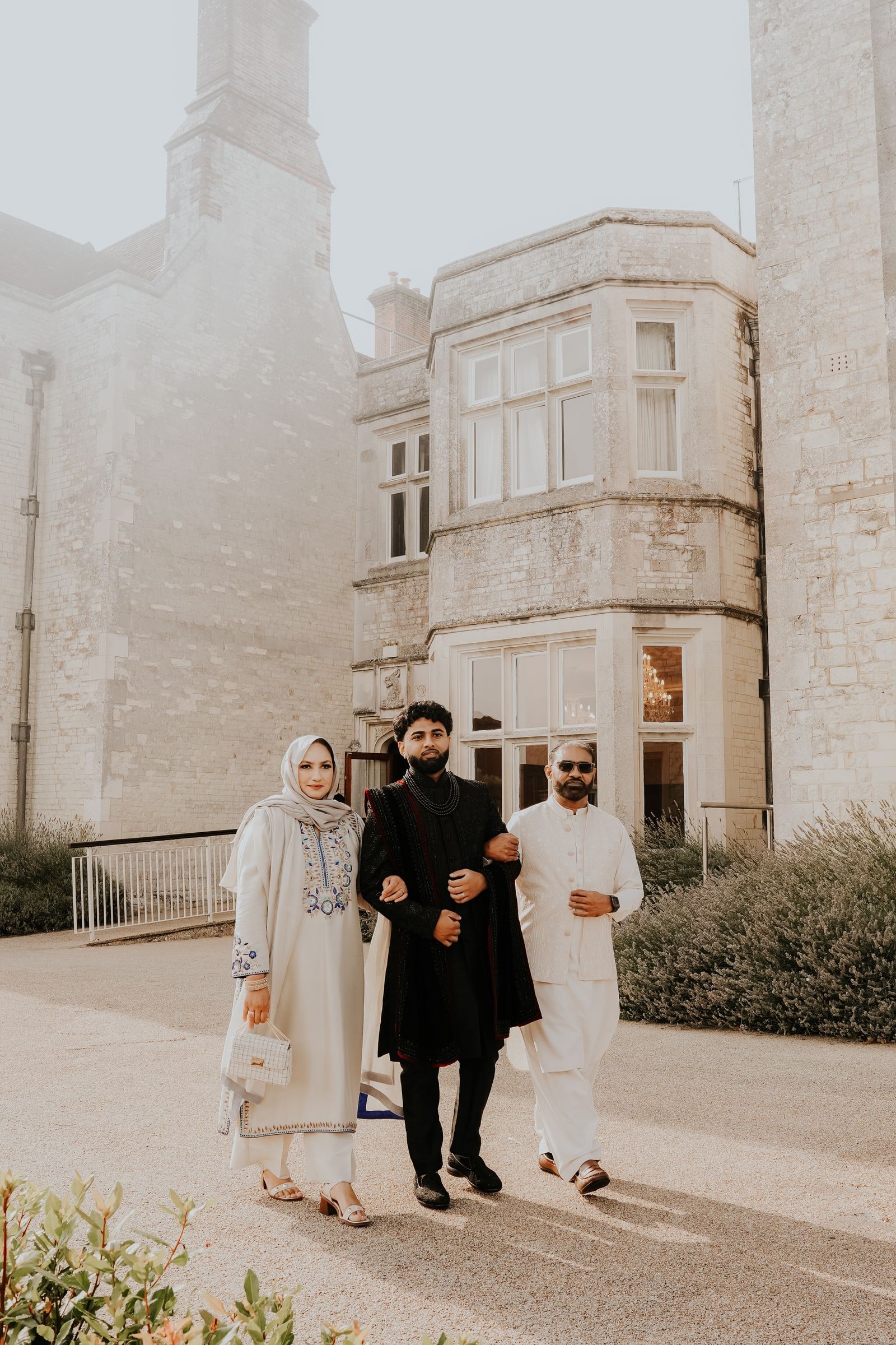 Groom walked in between two family members along the drive