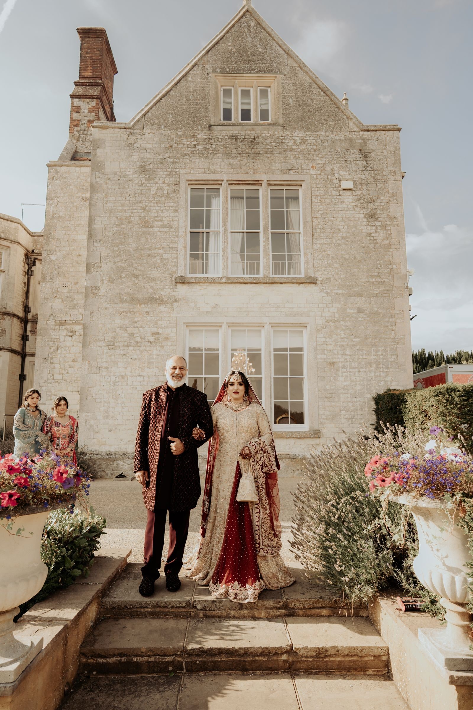 The bride walked down the stone steps of the house by her father