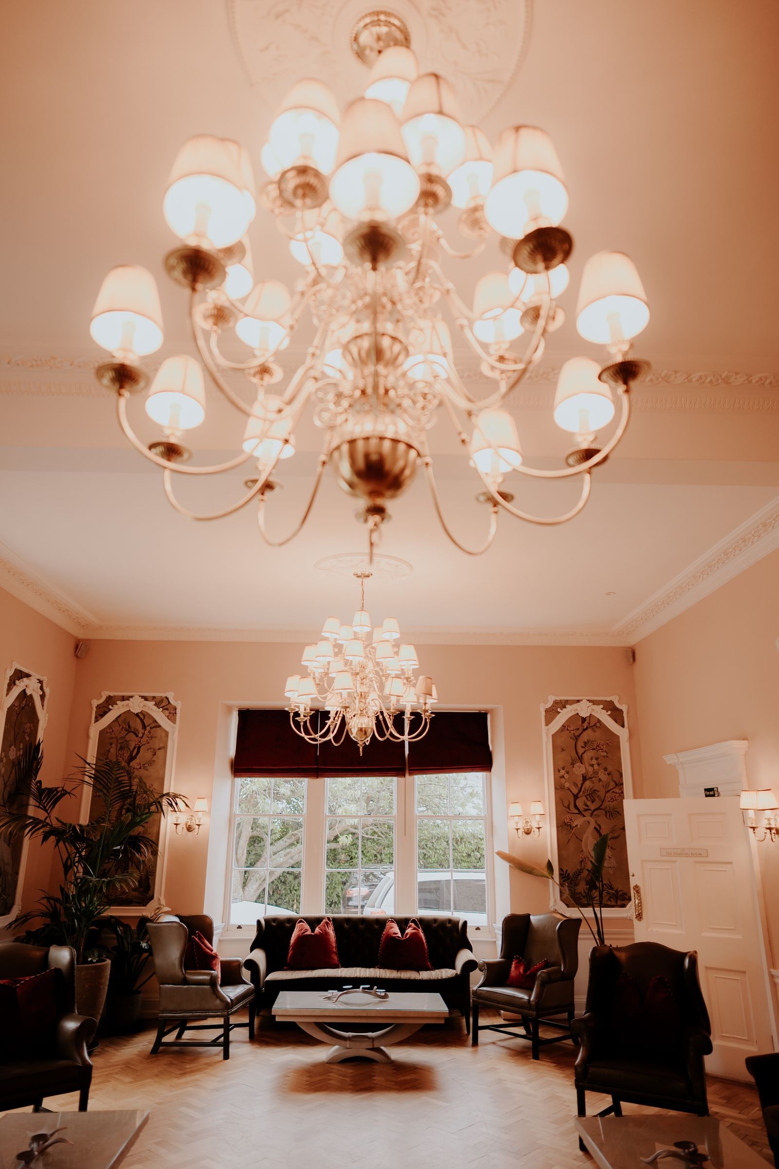 The drawing room with its chandelier, sofas and tall windows