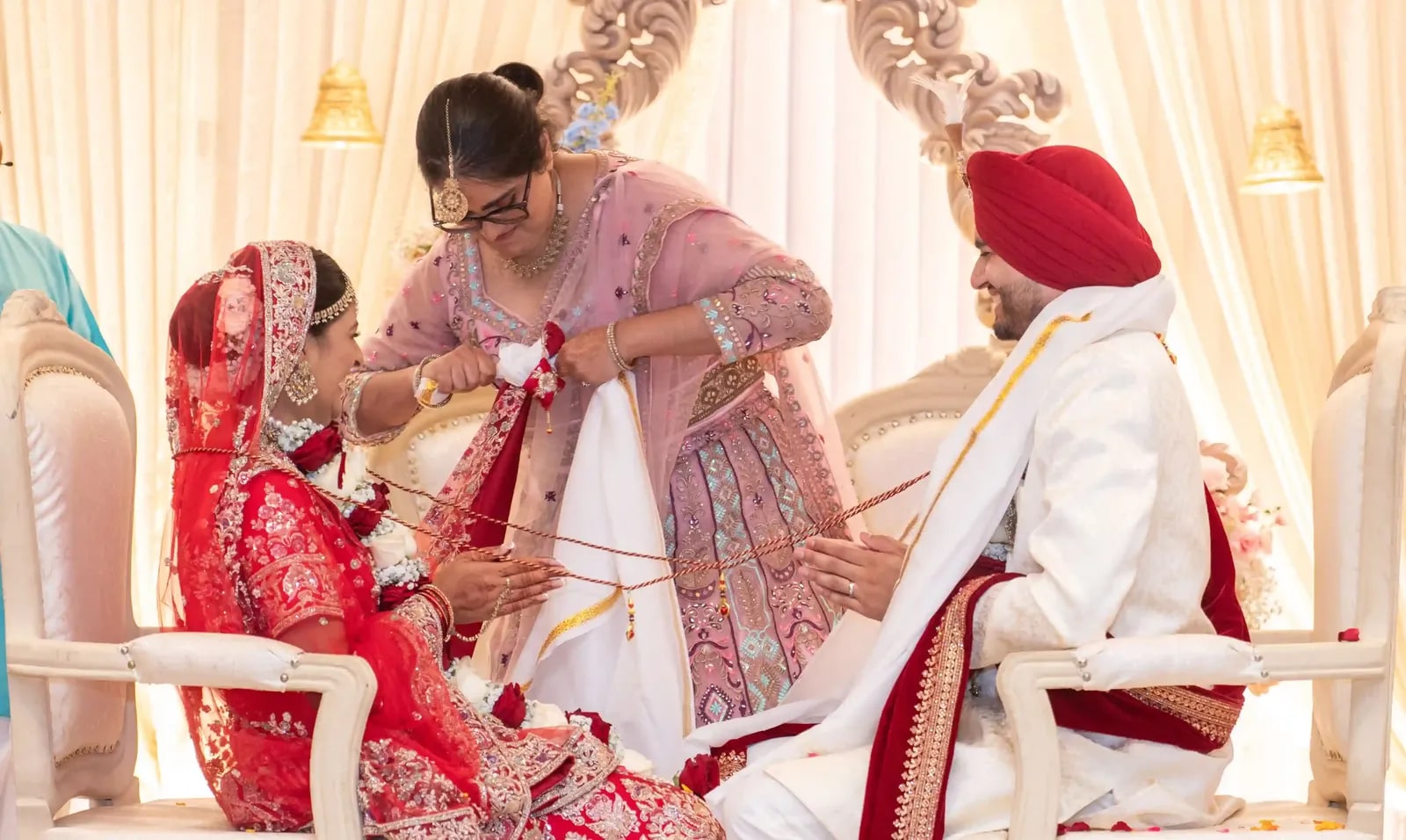 A thread being tied around the couple during the ceremony by the bride's mother