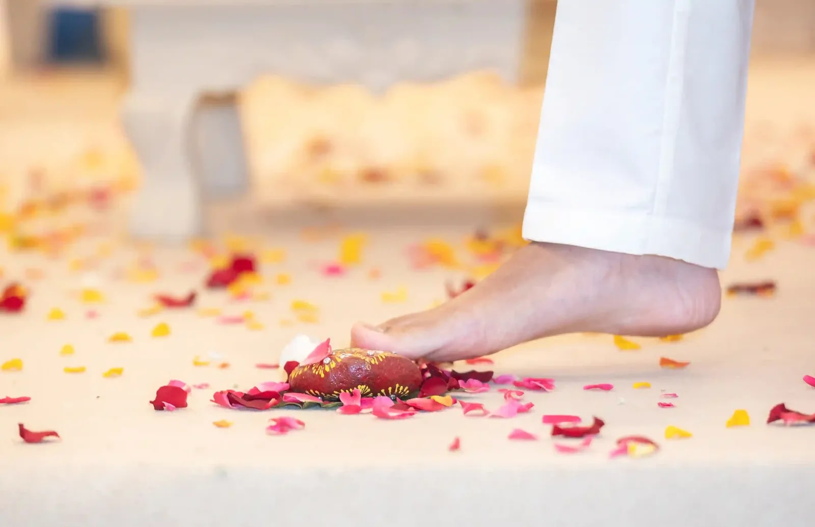 The couple's feet on the petal-strewn floor during the saptapadi