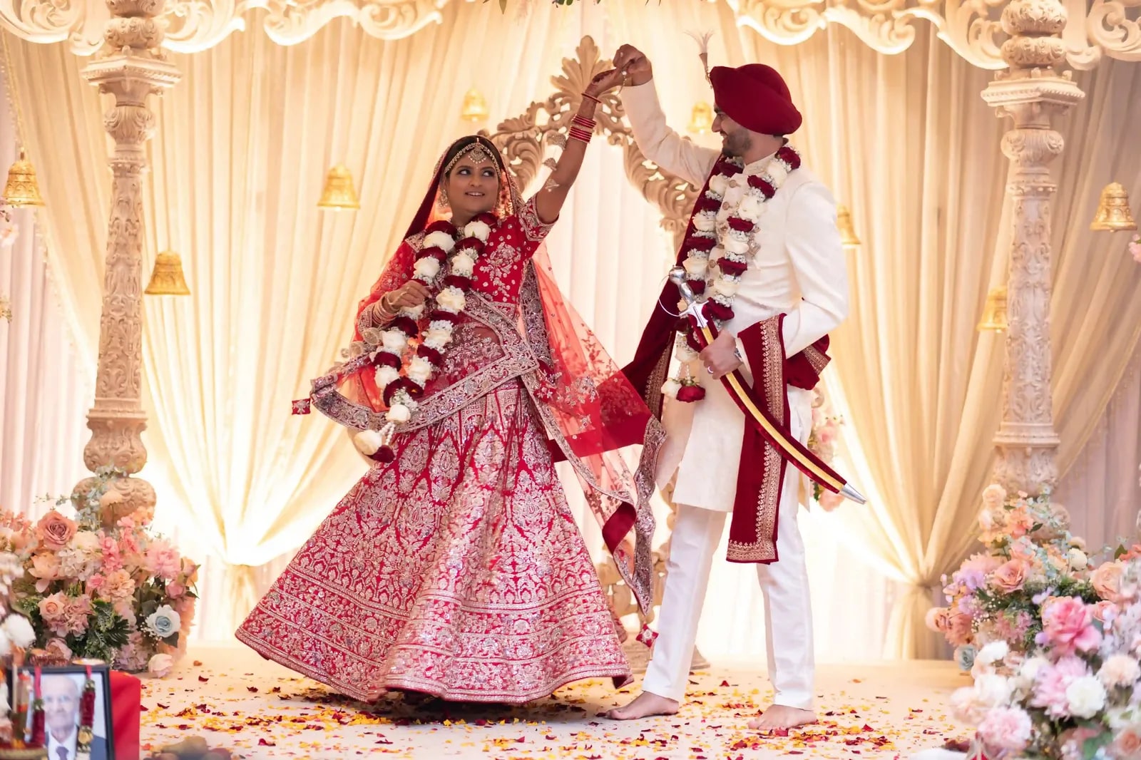 Groom turning his bride under his arm on the mandap, her lehenga flaring