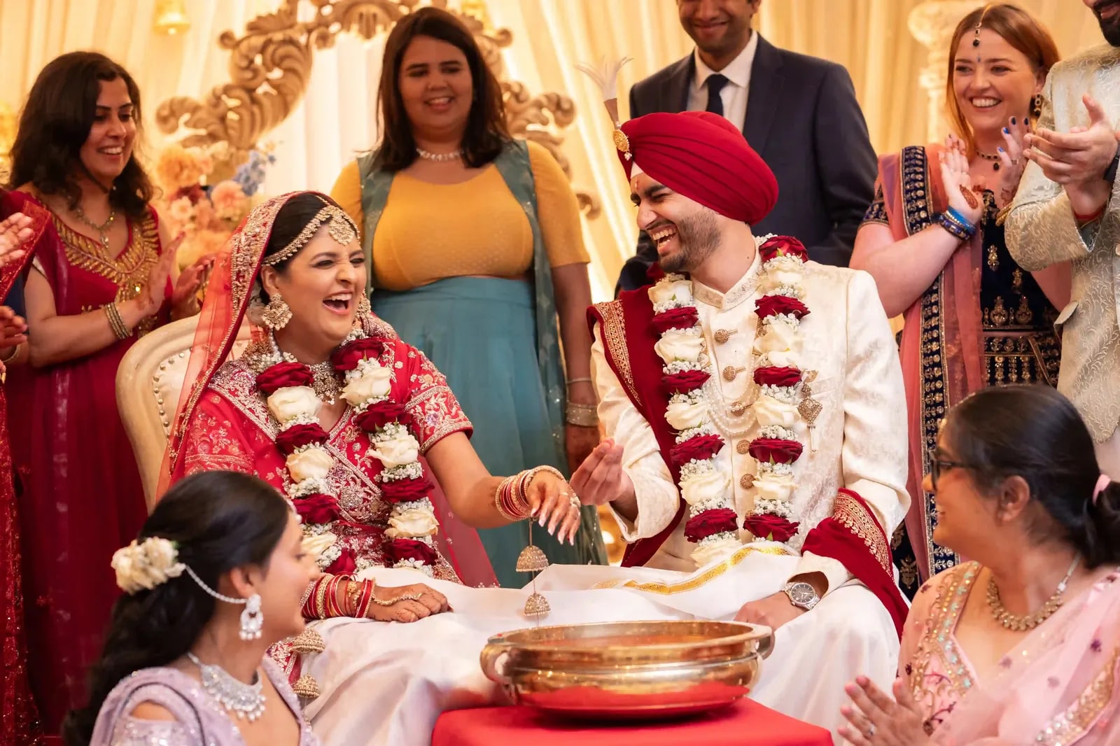 The couple playing the ring-finding game in a bowl, family laughing around them
