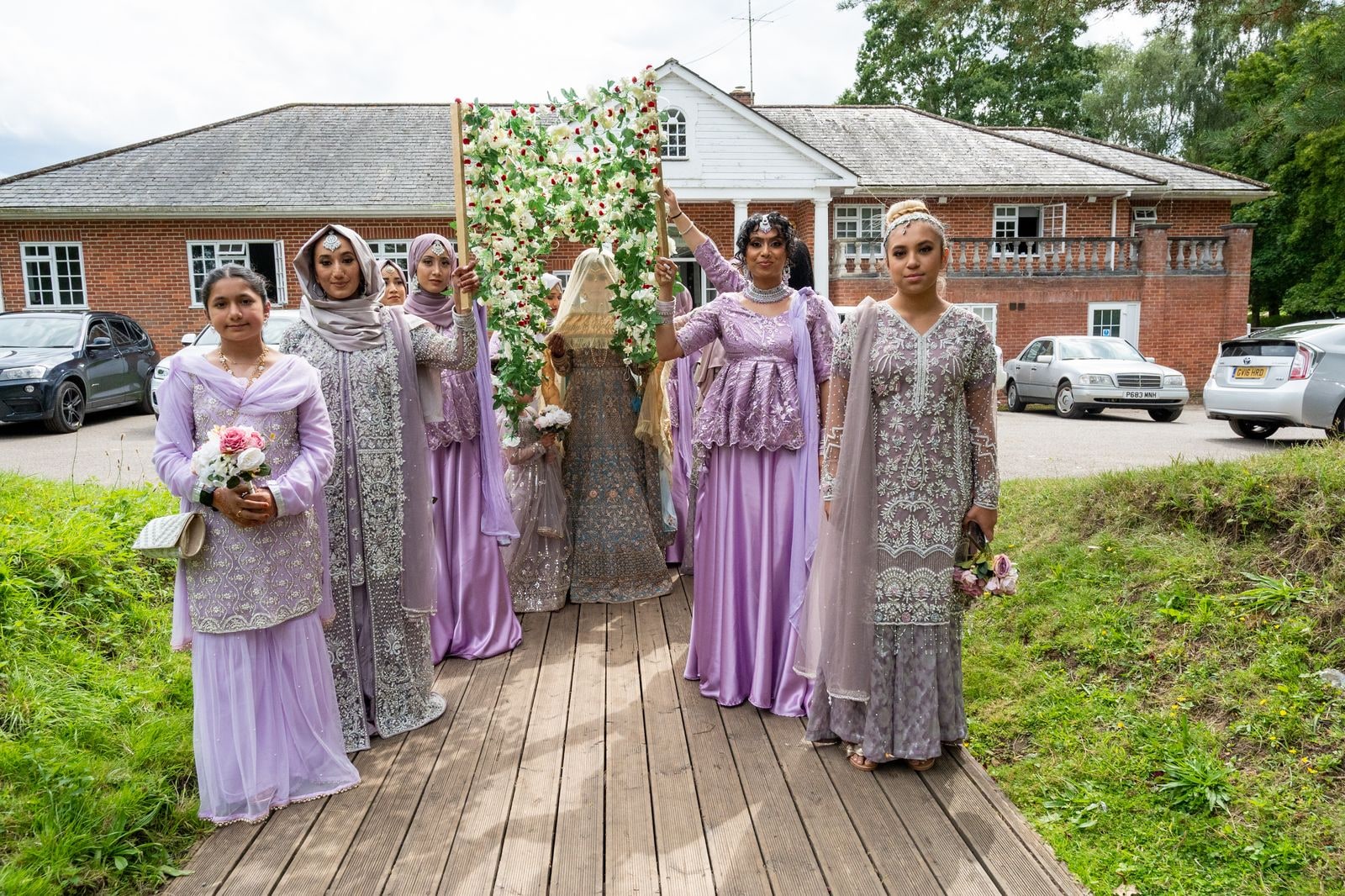 The bride's party in lilac walking the canopy along the boardwalk