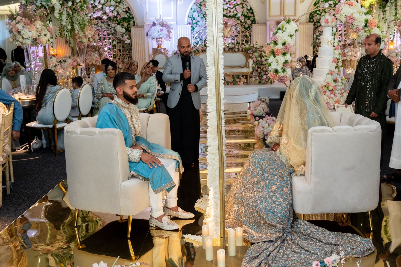 Bride and groom seated either side of a curtain during the nikkah