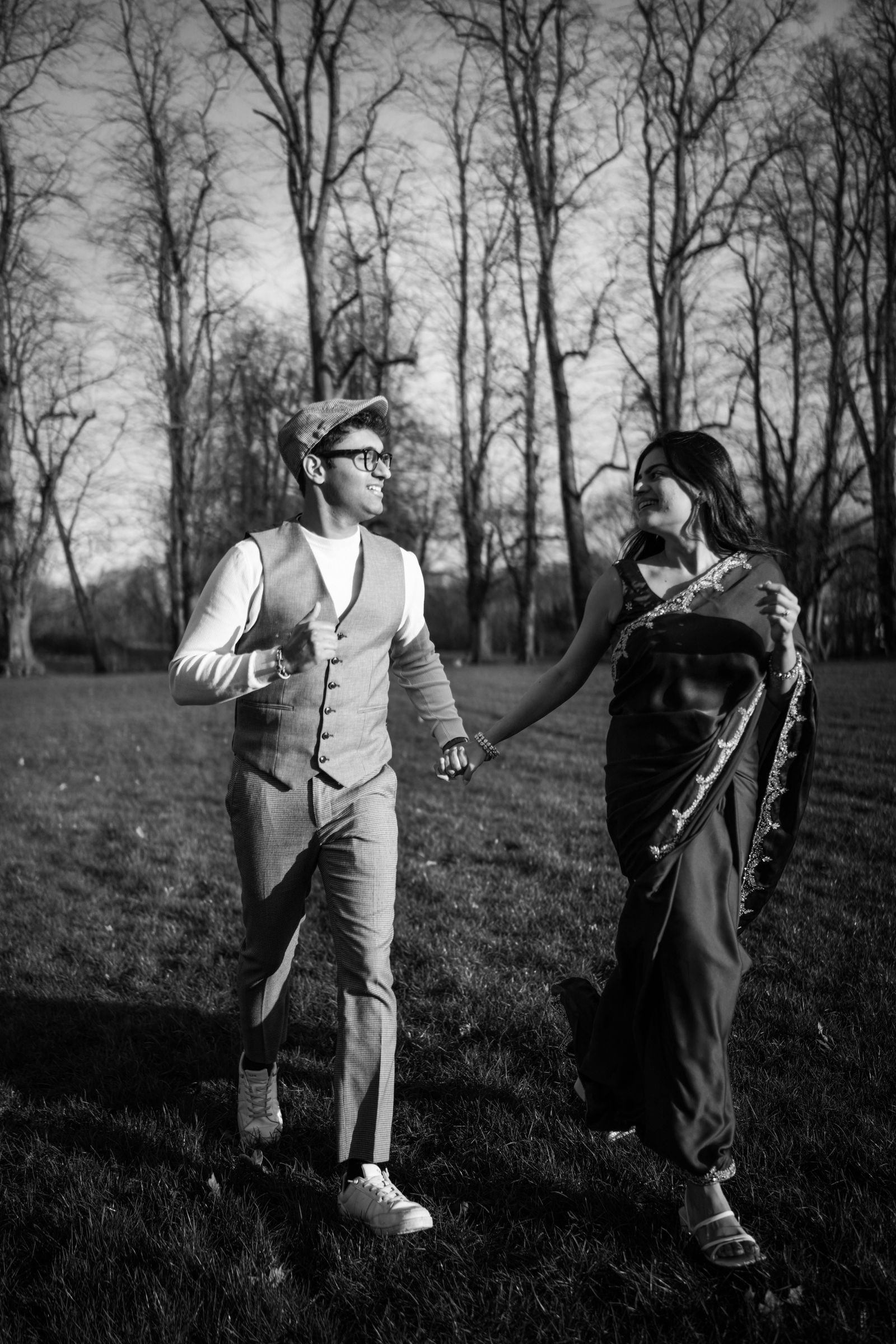 Couple walking through the winter parkland hand in hand, in black and white