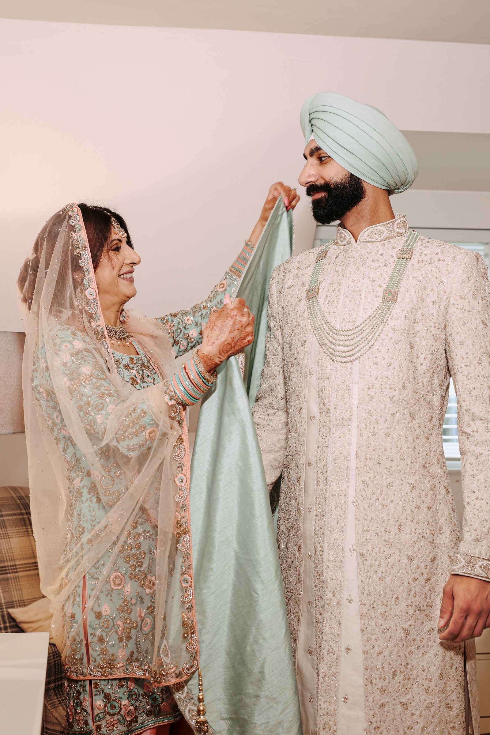 Bride holding the pale green palla as her groom stands beside her
