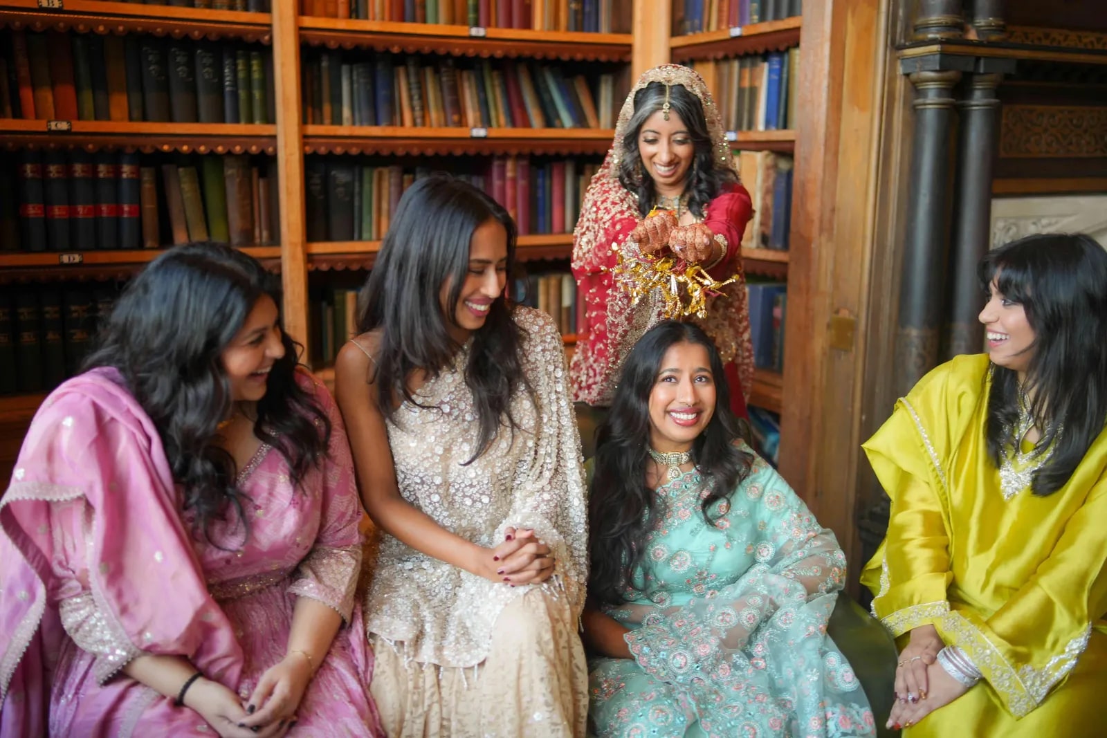 Bride laughing with four friends in the panelled library