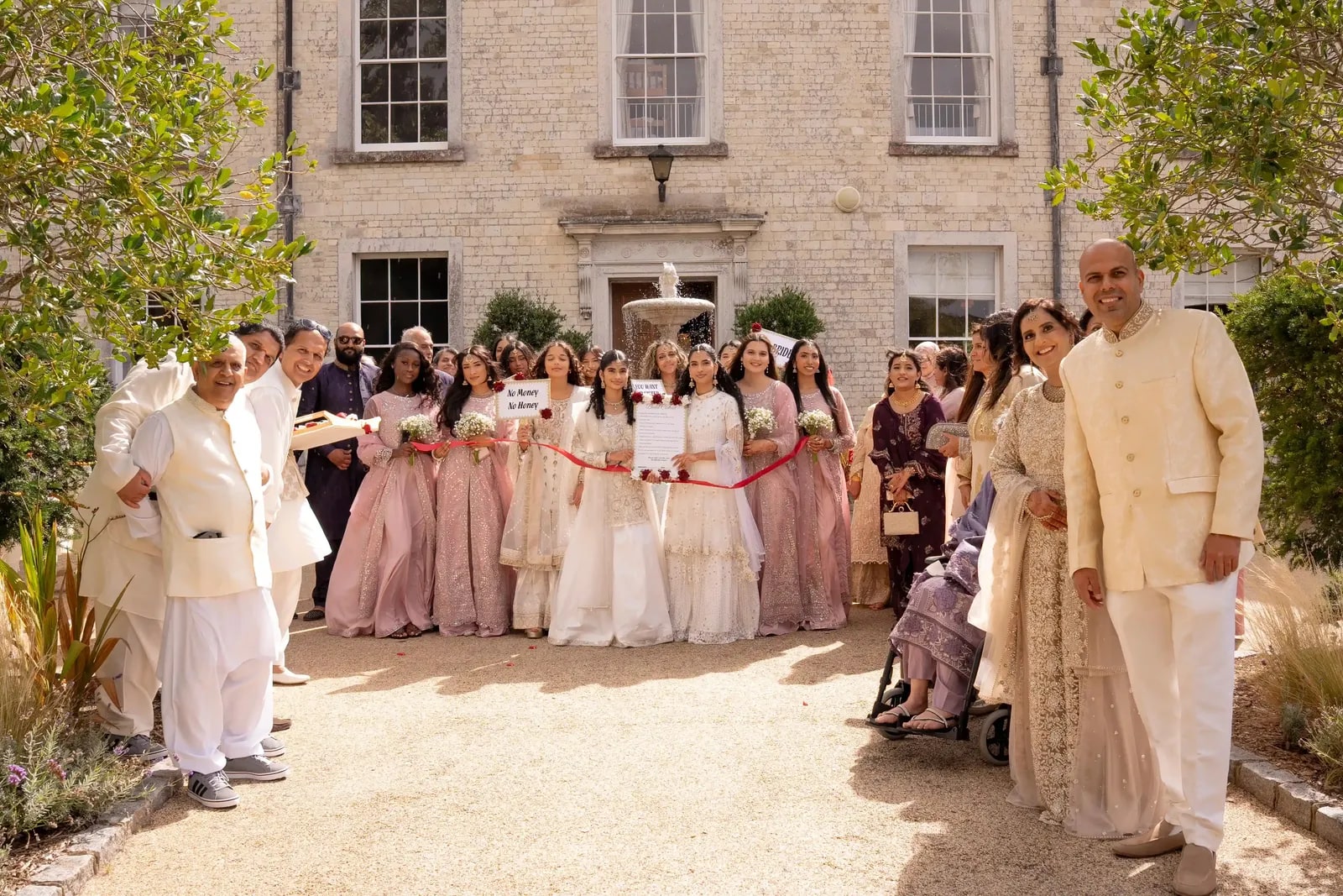 The bride's party holding a ribbon across the path to stop the groom entering