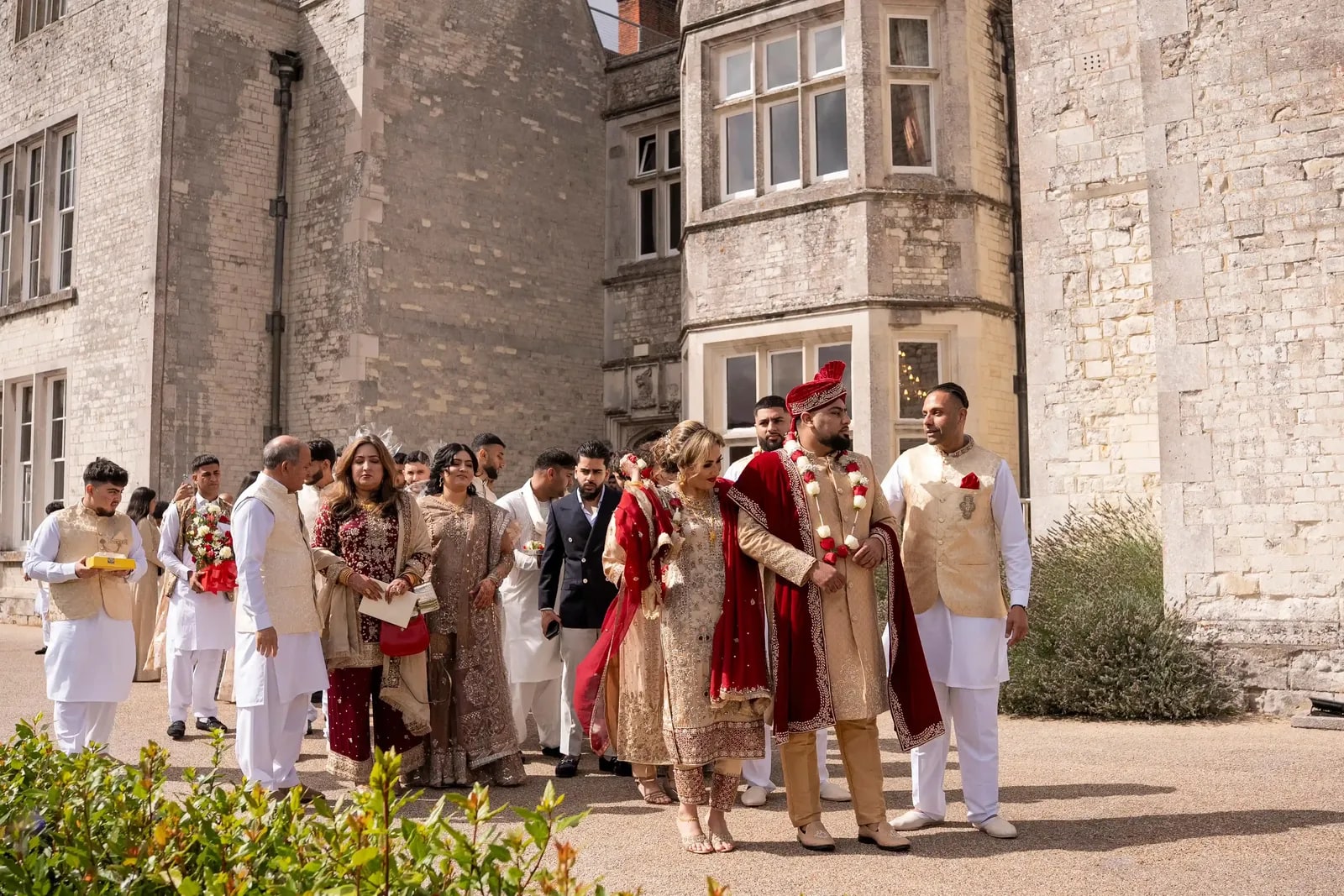 Families meeting outside the house, the groom in red among them