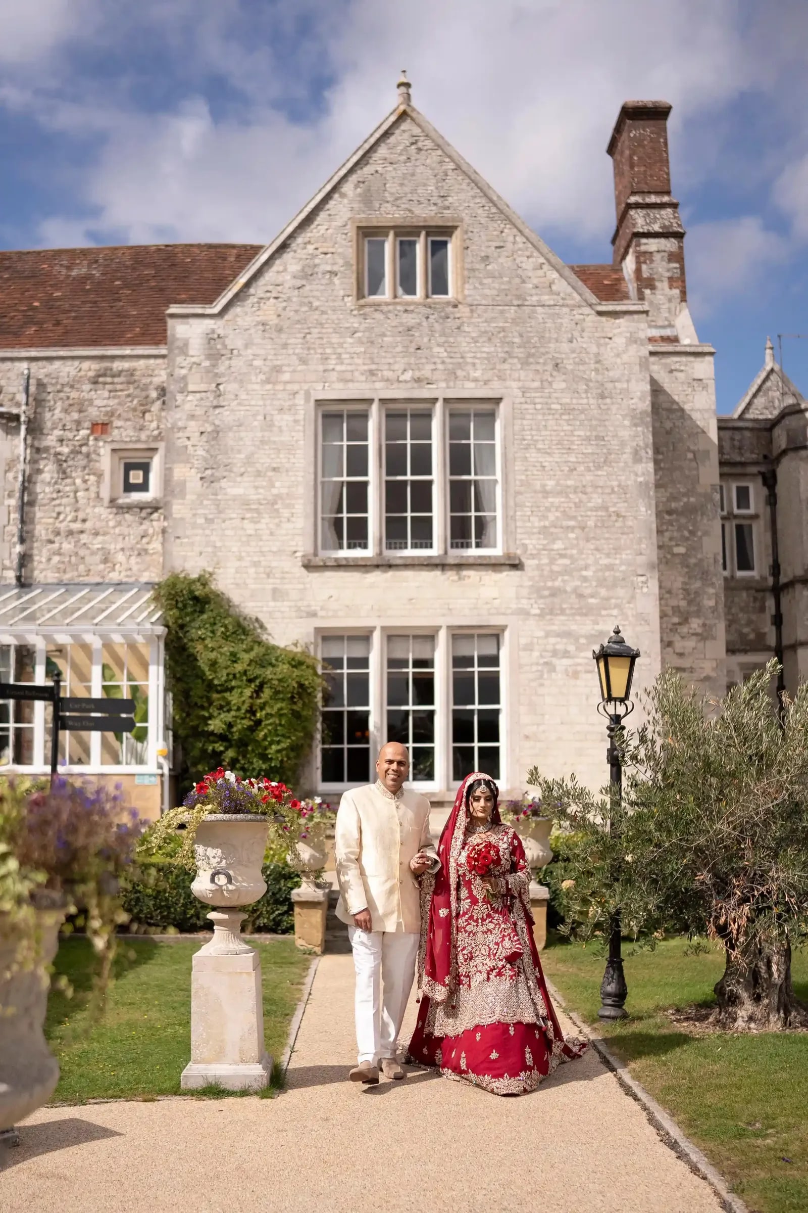 The bride's father walking her along the garden path towards the ceremony