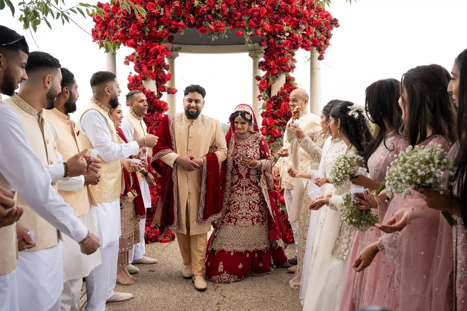 Guests pressing in around the couple as they come away from the arch