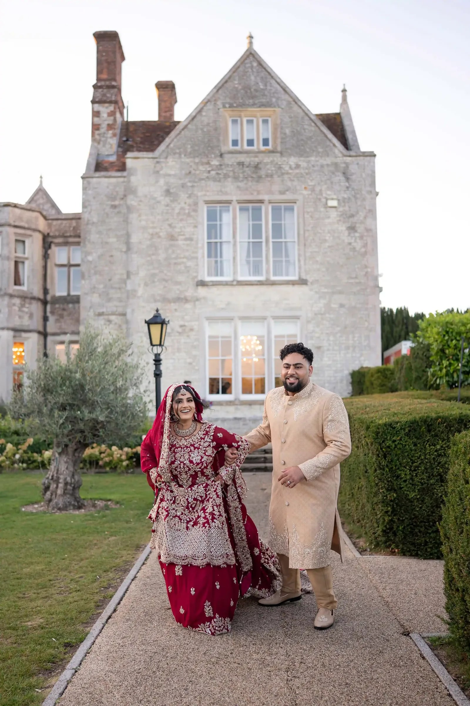 Couple walking the path towards the camera, the house lit behind them