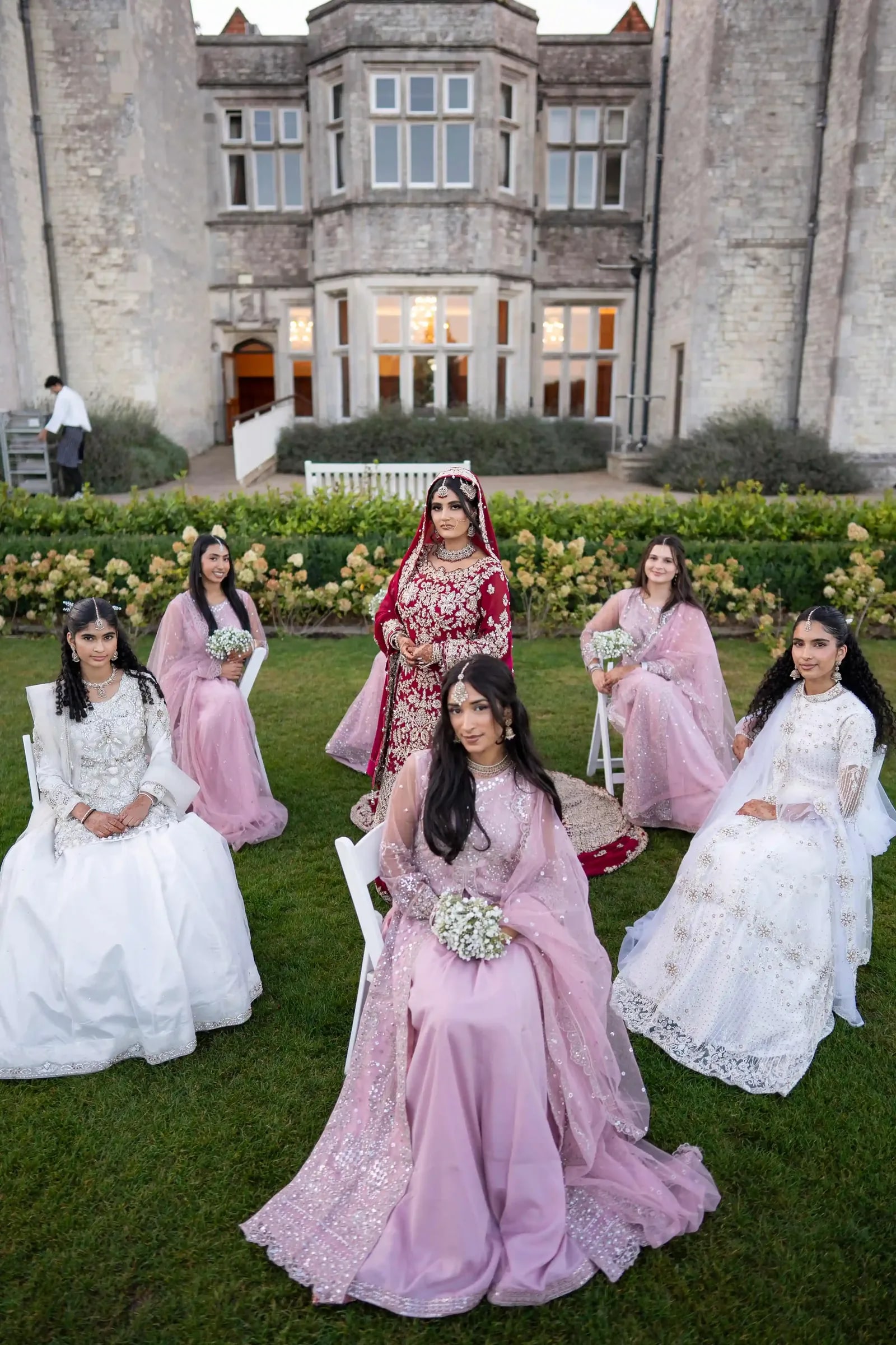 Bride and her party on the lawn in pinks and ivory at dusk