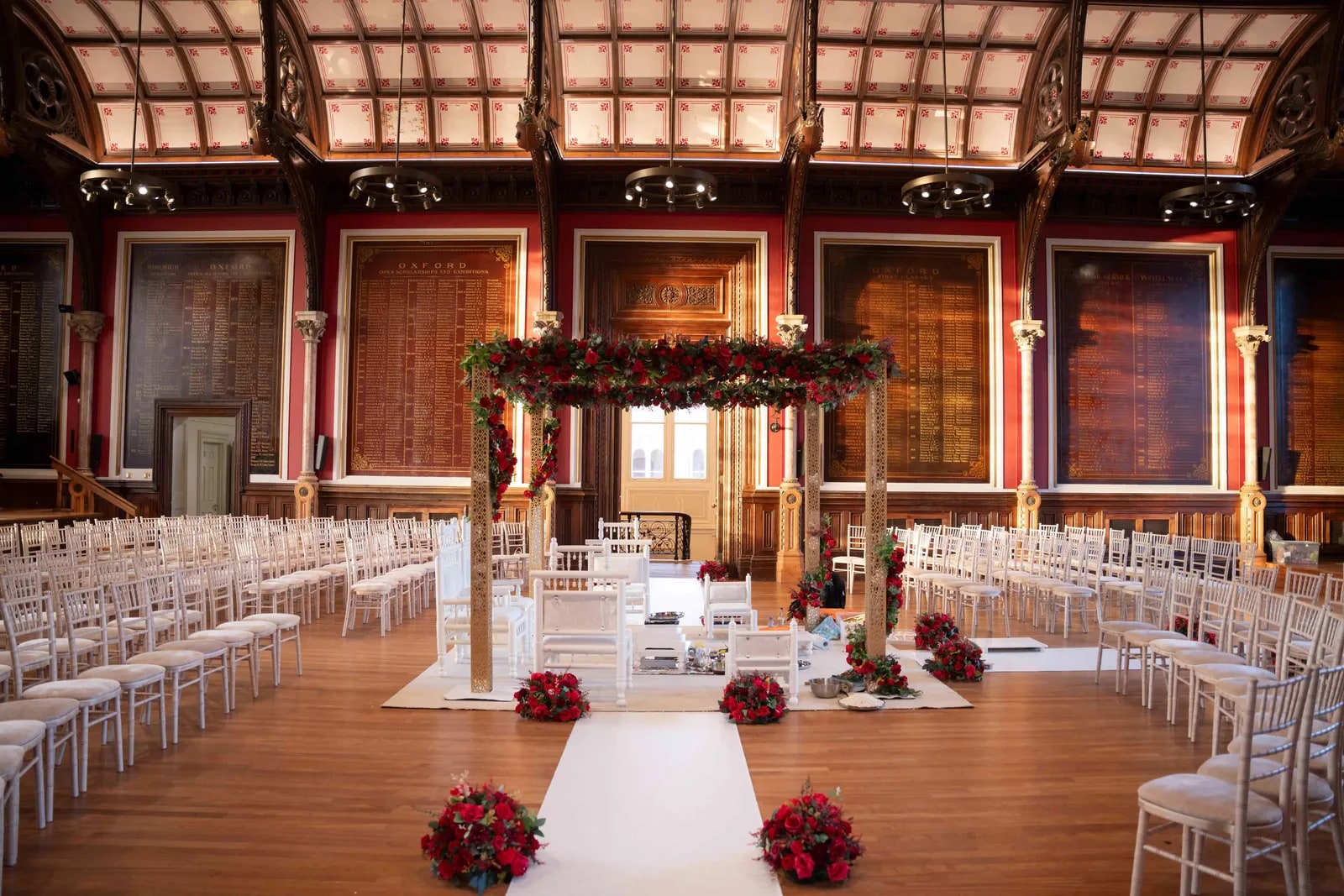 The ceremony hall set with white chairs and a flowered arch at the aisle end