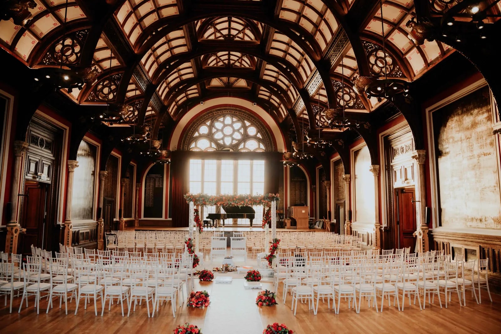 The vaulted hall from the back, rows of chairs facing the flowered mandap