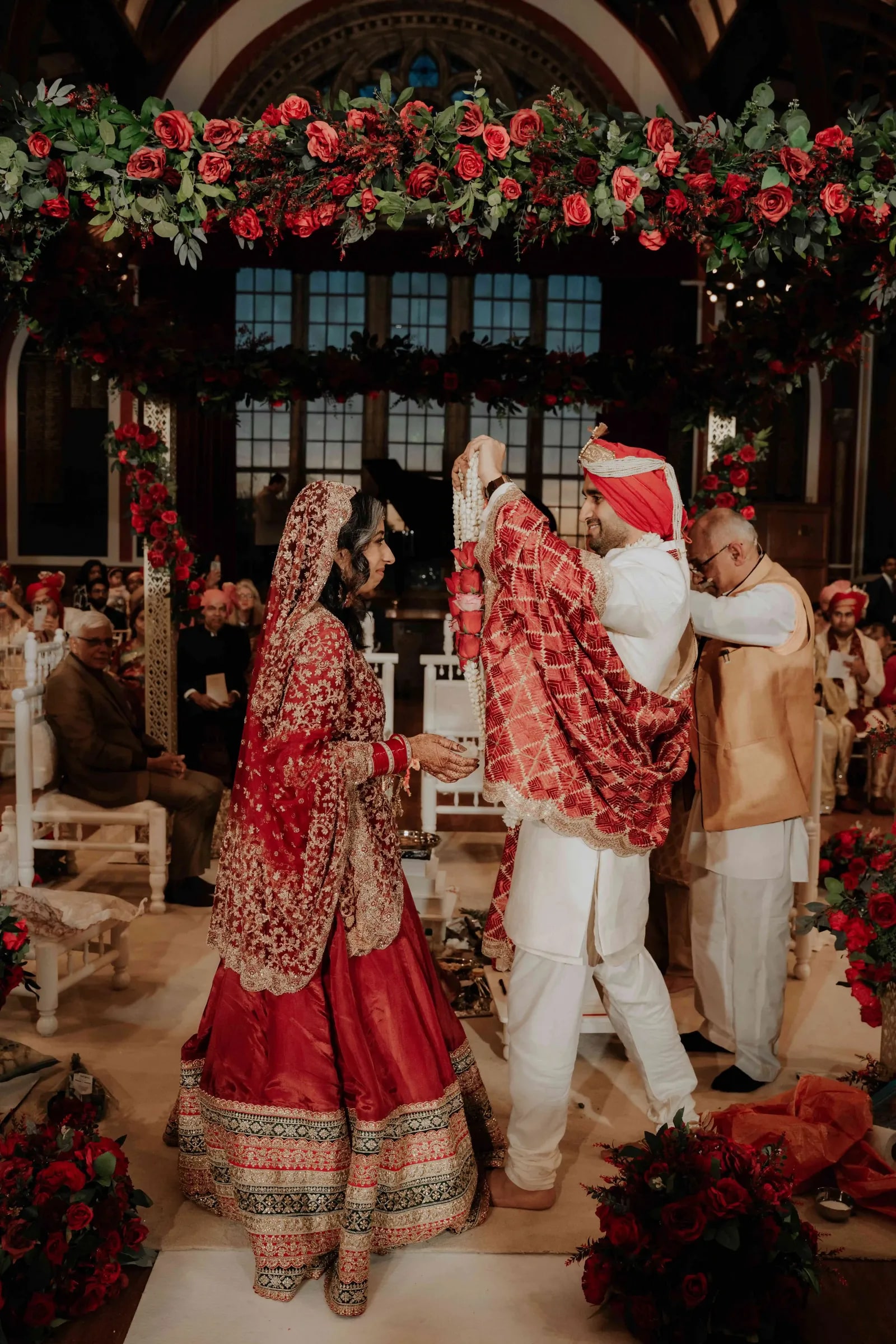 Bride and groom facing each other at the mandap, family close behind