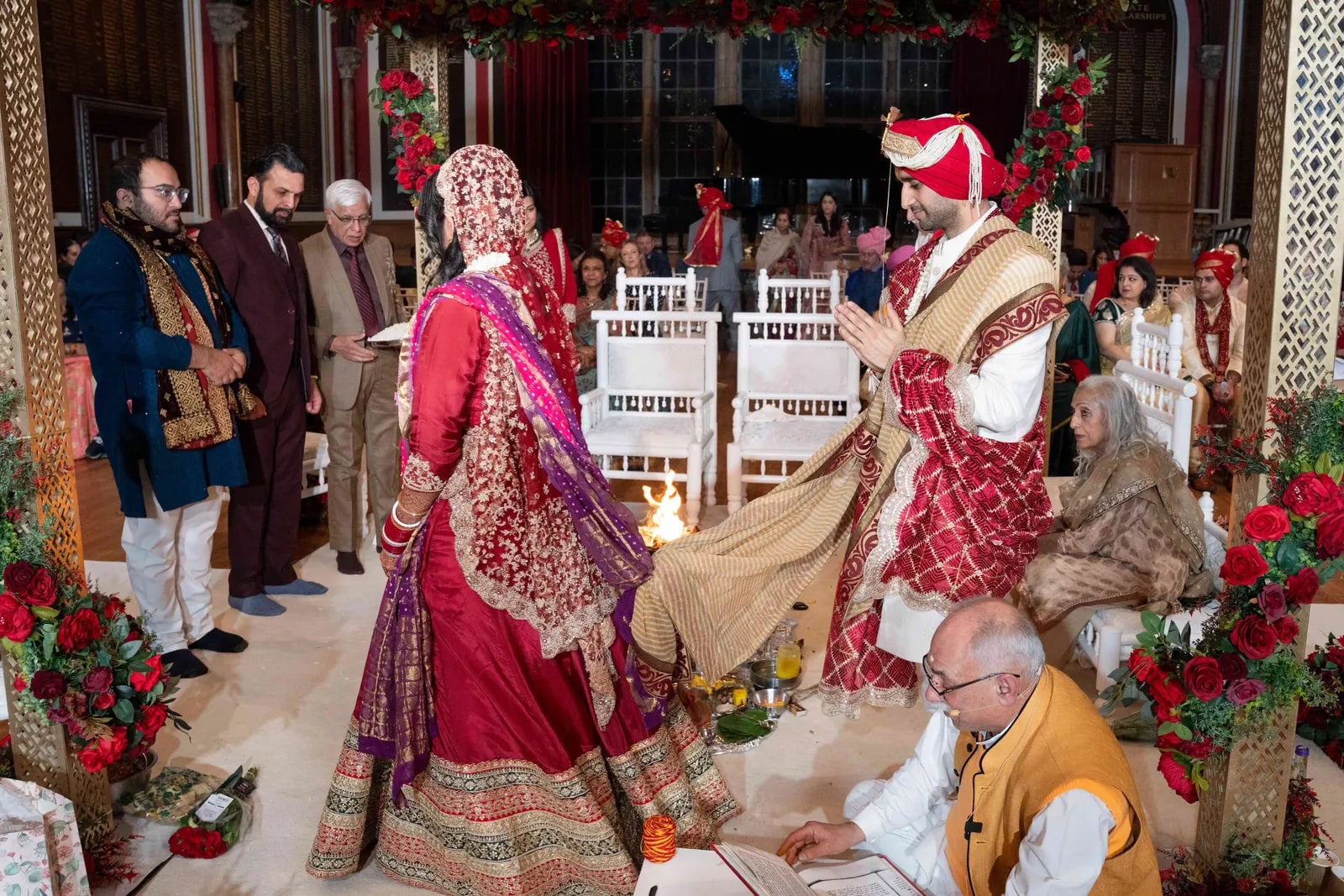 Bride and groom taking the pheras around the fire, joined by the knotted cloth