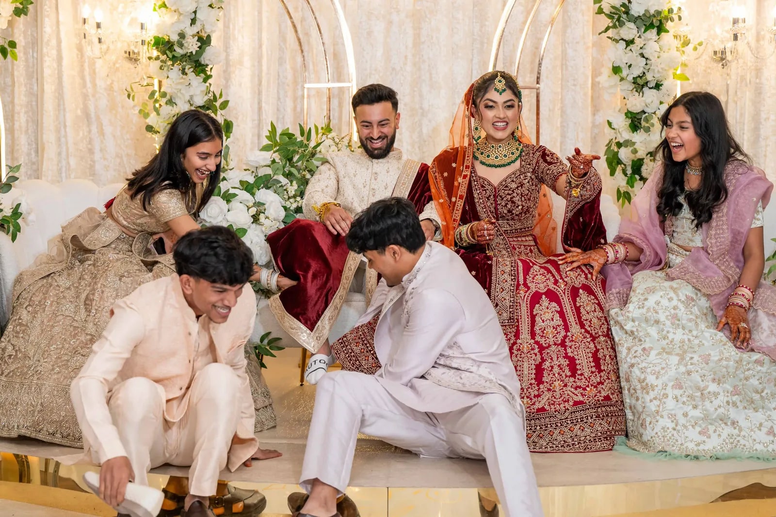 The joota chupai, two young men hiding the groom's shoes as the family laugh