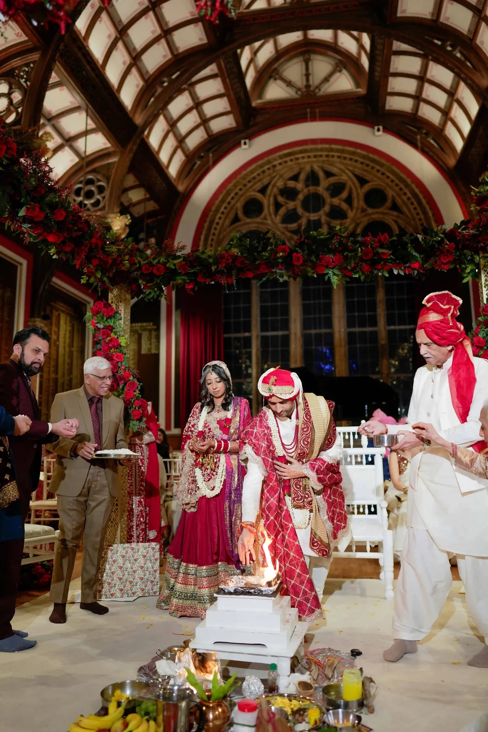 The couple at the mandap before the sacred fire, the priest reading beside them