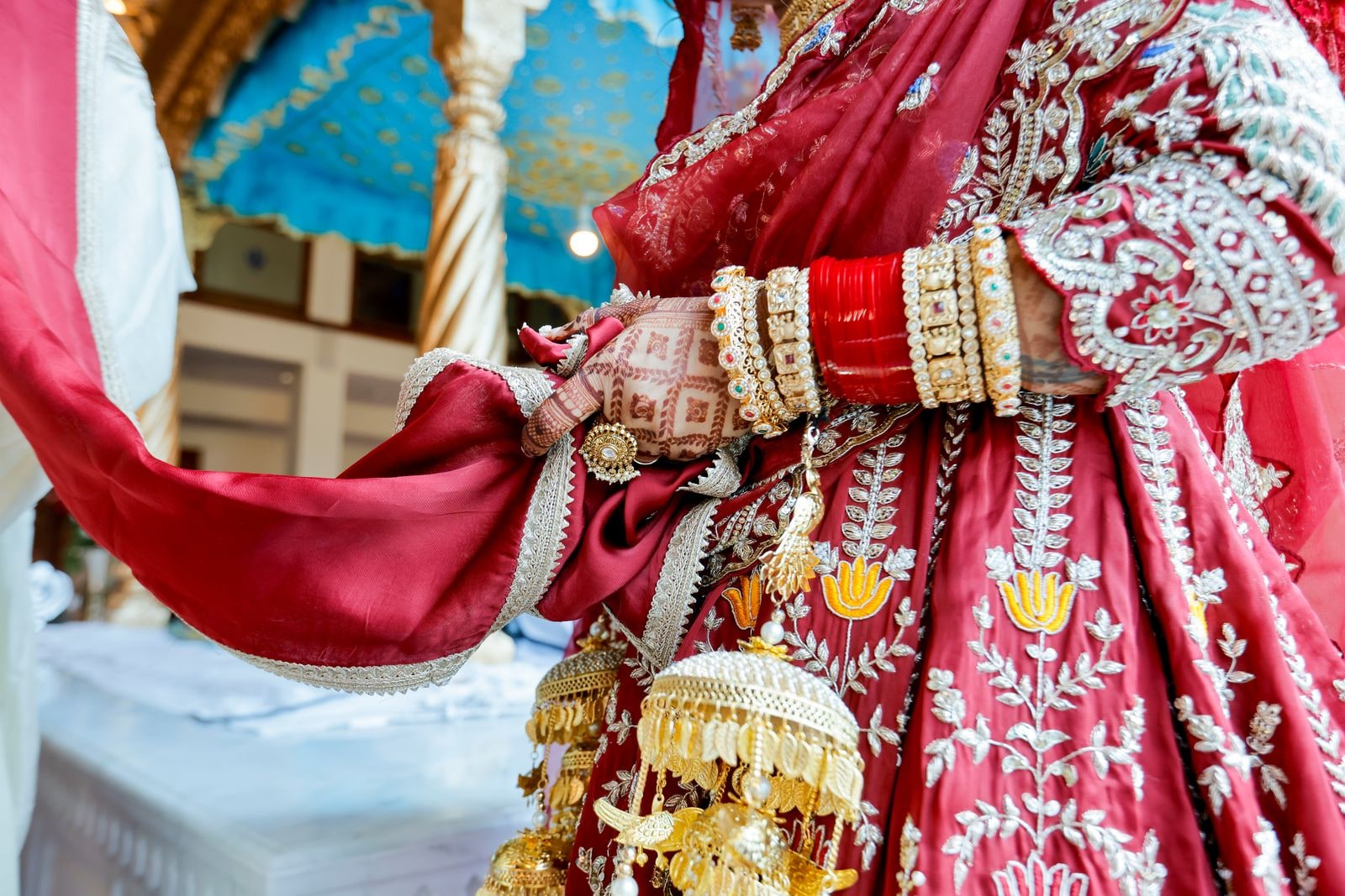 Close view of the bride's red chura and gold kalire against her lehenga