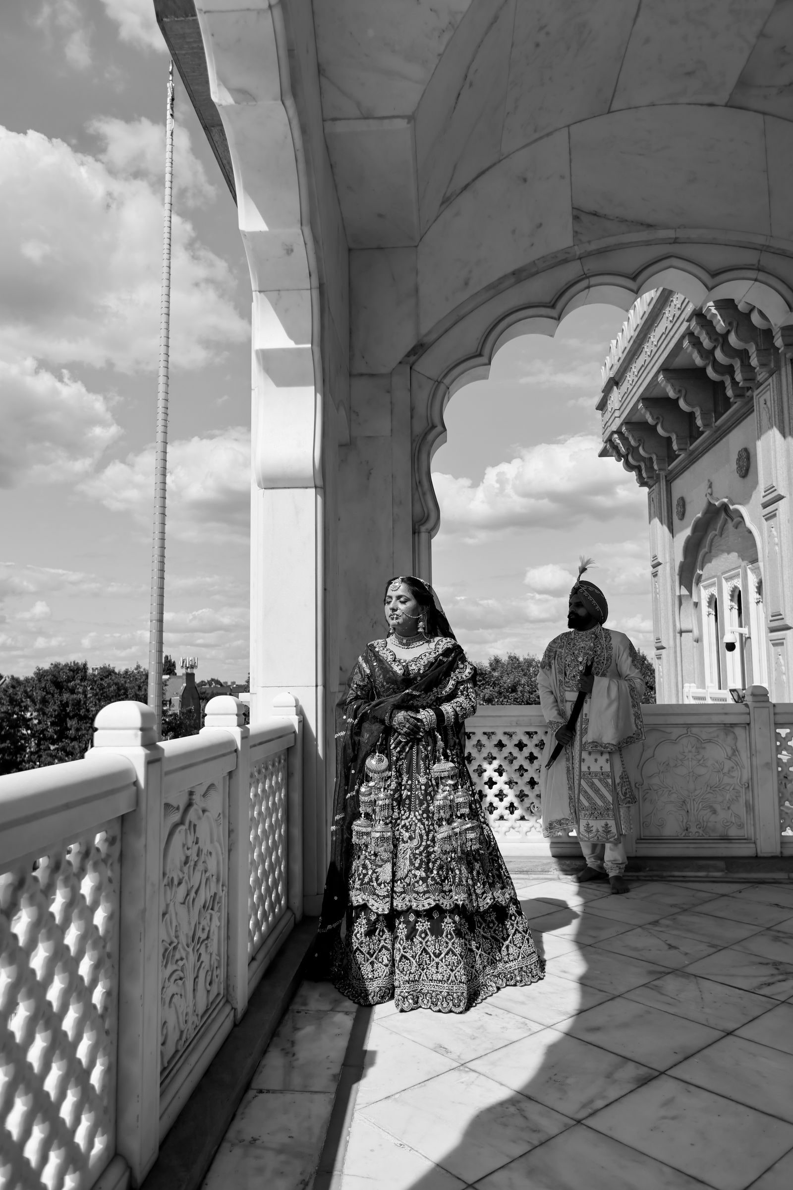 Bride walking the marble arcade of the gurdwara, in black and white