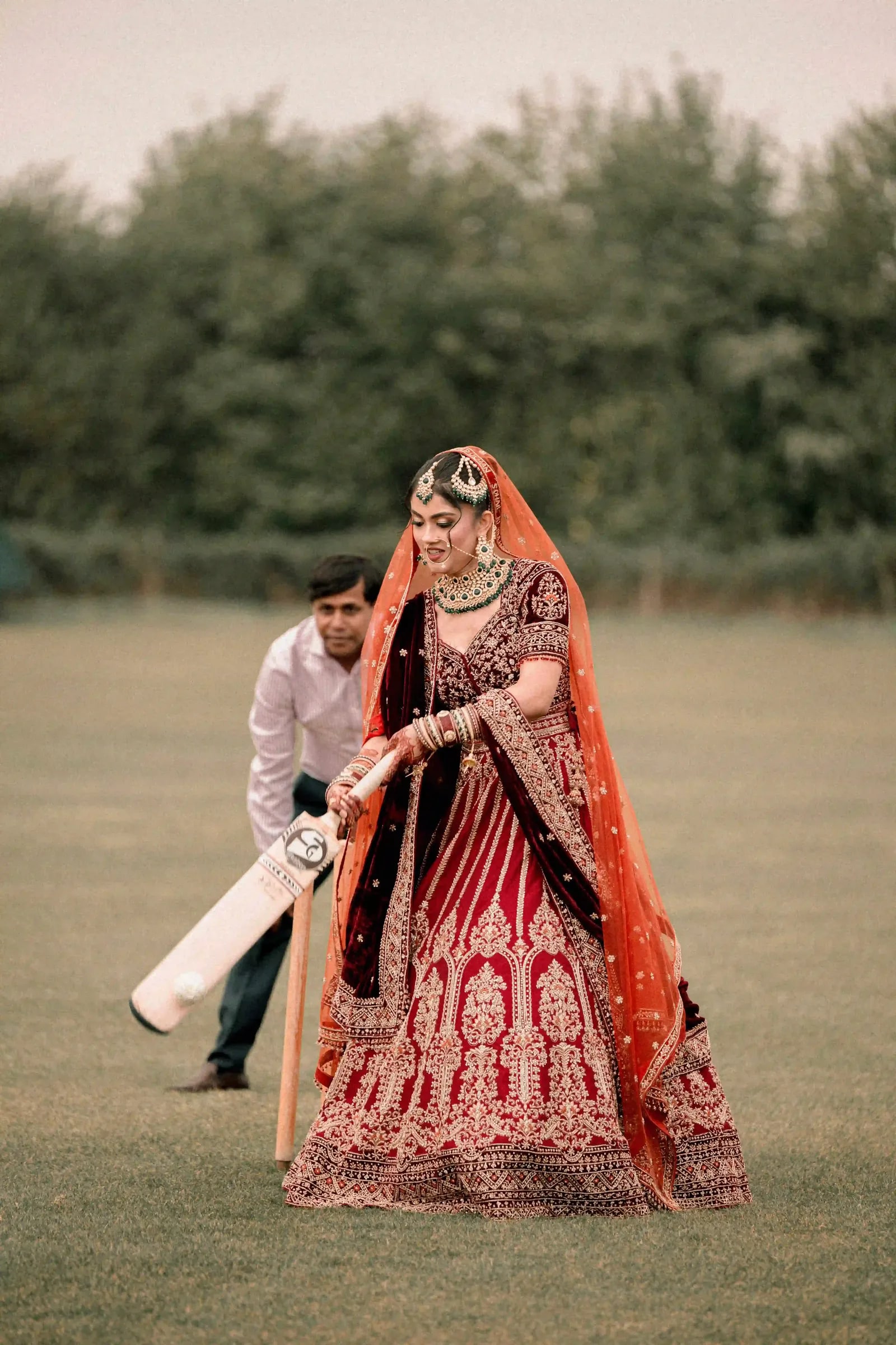 Bride batting with a guest keeping wicket behind her
