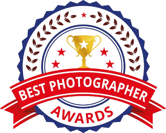 A badge featuring a golden trophy surrounded by laurel leaves and a red ribbon that reads "Best Photographer Awards." The design emphasizes excellence in photography.