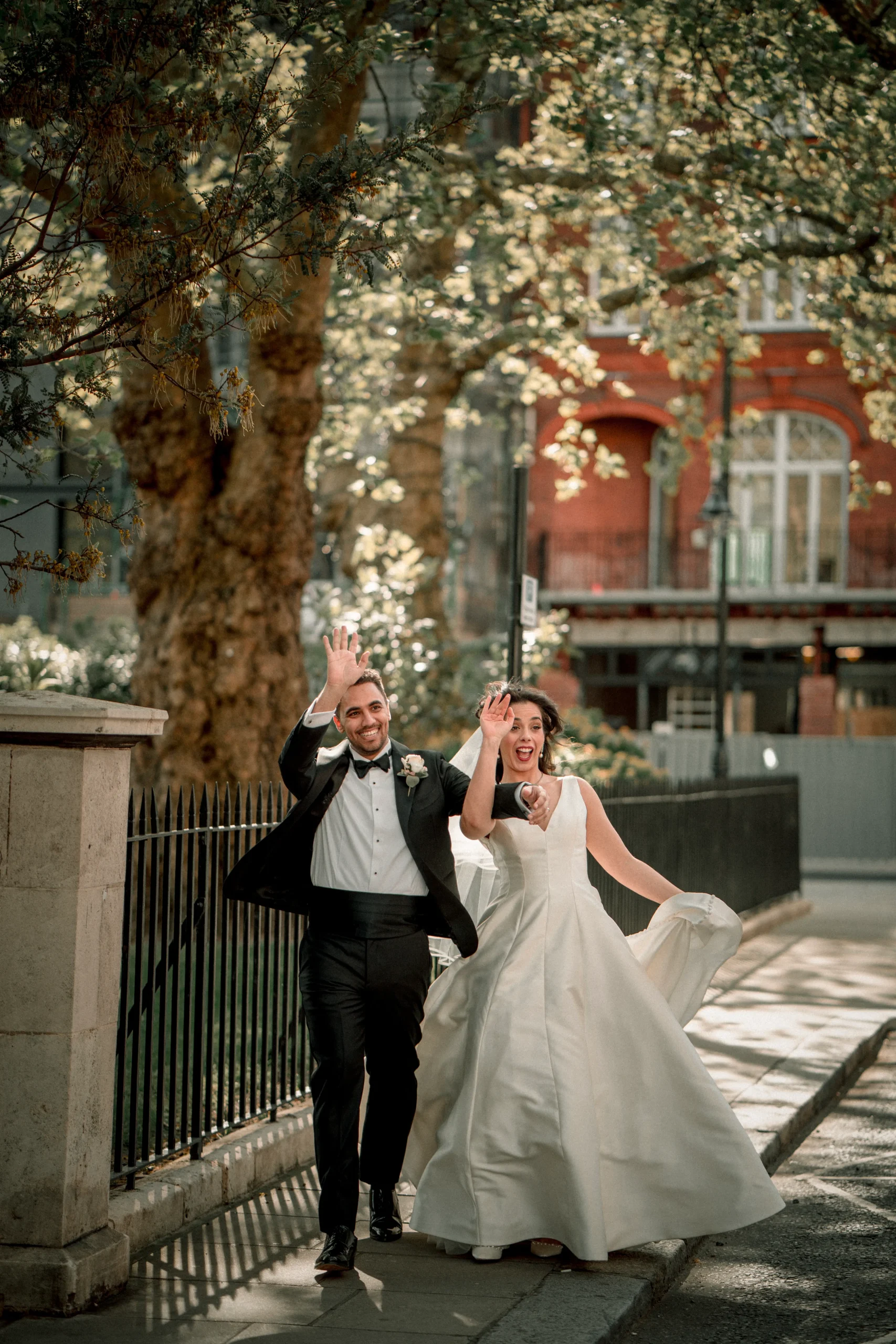A couple saying good bye to guest after their happy wedding in london captured wedding photographer in london