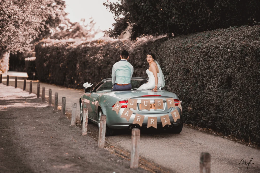 An emotional shoot of couple sitting on a car by wedding photographer in London UK.