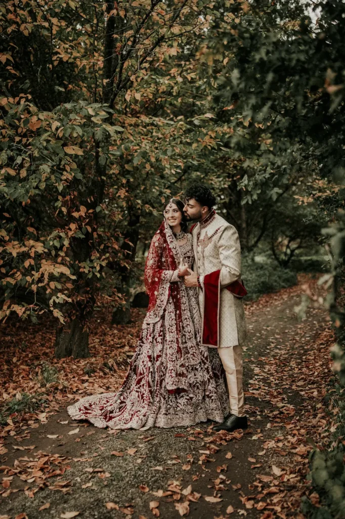 Muslim newlyweds sharing an intimate moment on an autumn woodland path captured by muslim wedding photographer London UK