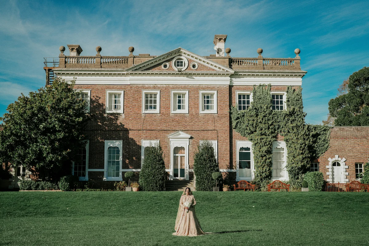 Bride and groom arriving by vintage wedding car at a grand London wedding venue with their wedding photographer and videographer in london