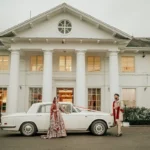 Muslim bride and groom beside a vintage Rolls-Royce outside their London wedding venue with their wedding photographer near me