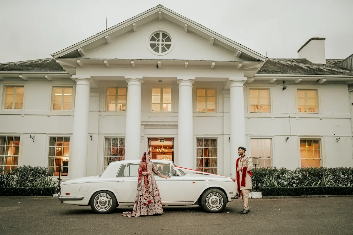 Muslim bride and groom beside a vintage Rolls-Royce outside their London wedding venue with their wedding photographer near me