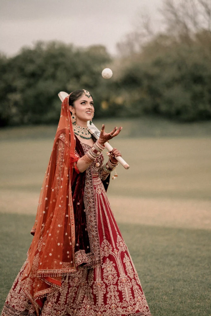 Hindu bride holding ceremonial sword in garden setting