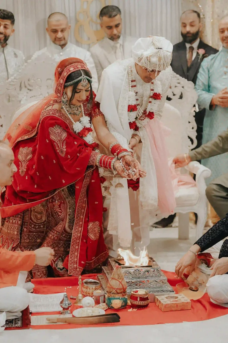 Hindu bride and groom exchanging floral garlands during Varmala ceremony by their Hindu wedding photographer London