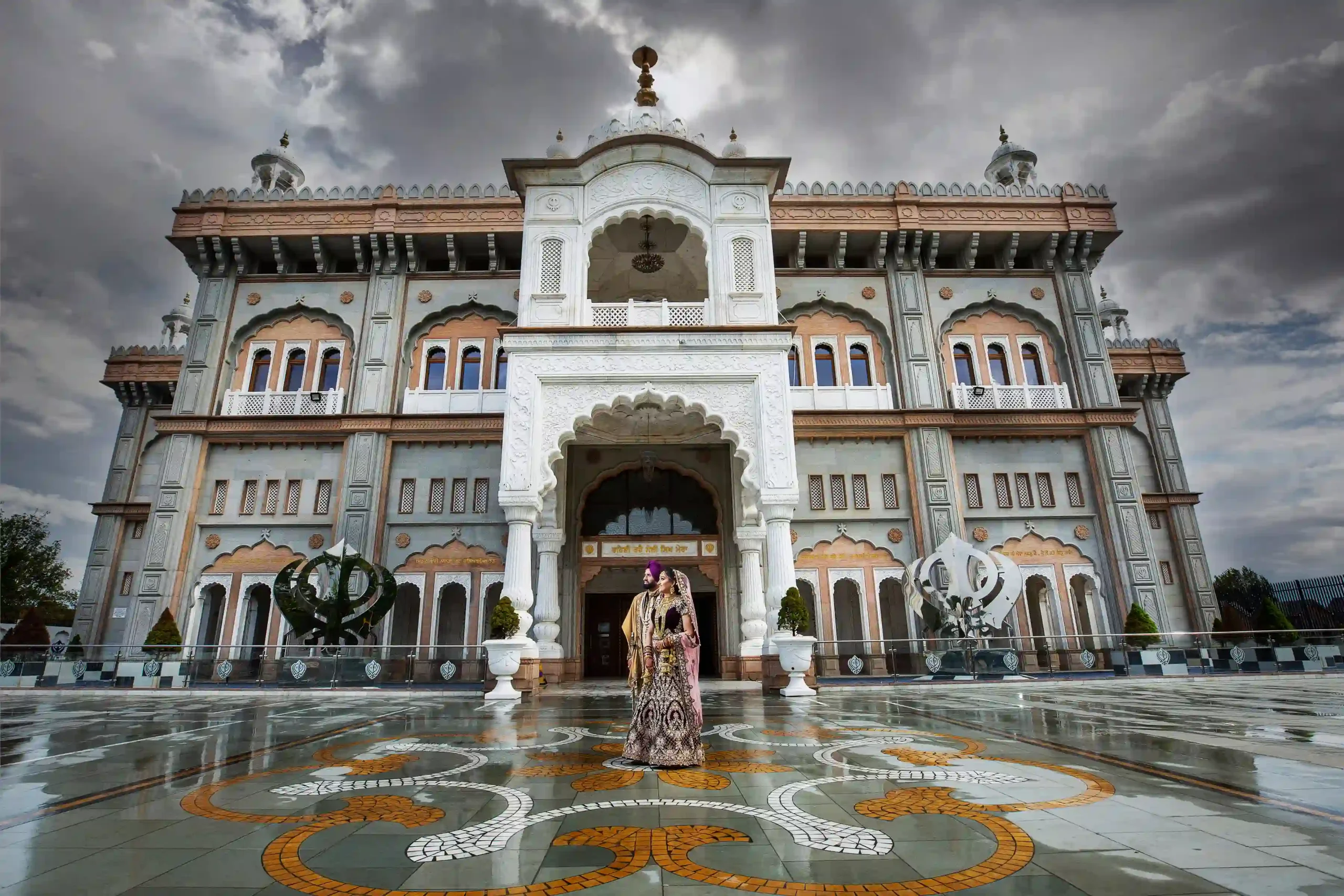 ikh bride and groom in traditional wedding attire standing outside a London Gurdwara featured in an Asian wedding photography and videography portfolio